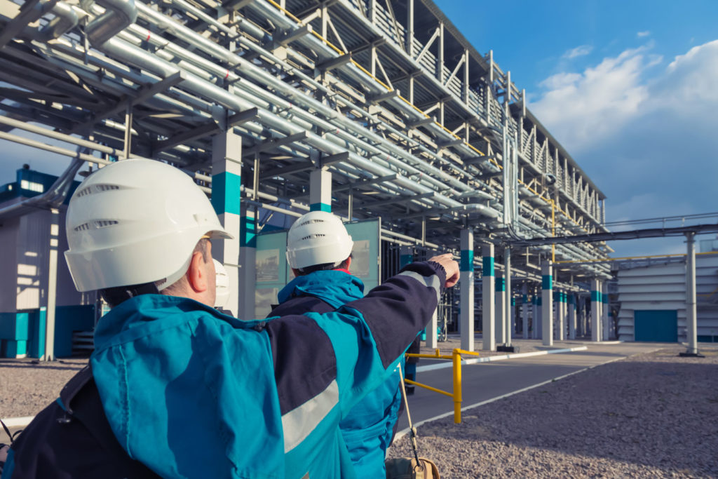 Young employees in a chemical plant wearing safety helmets